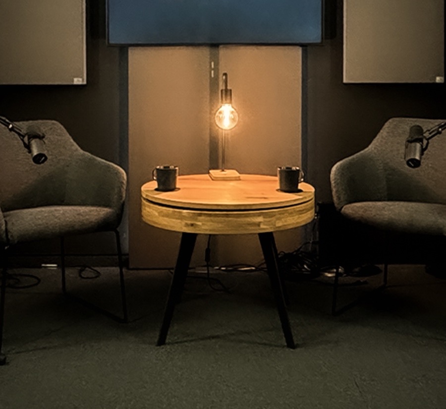 Kleiner Studiotisch mit zwei Mikrofonen und zwei Sesseln