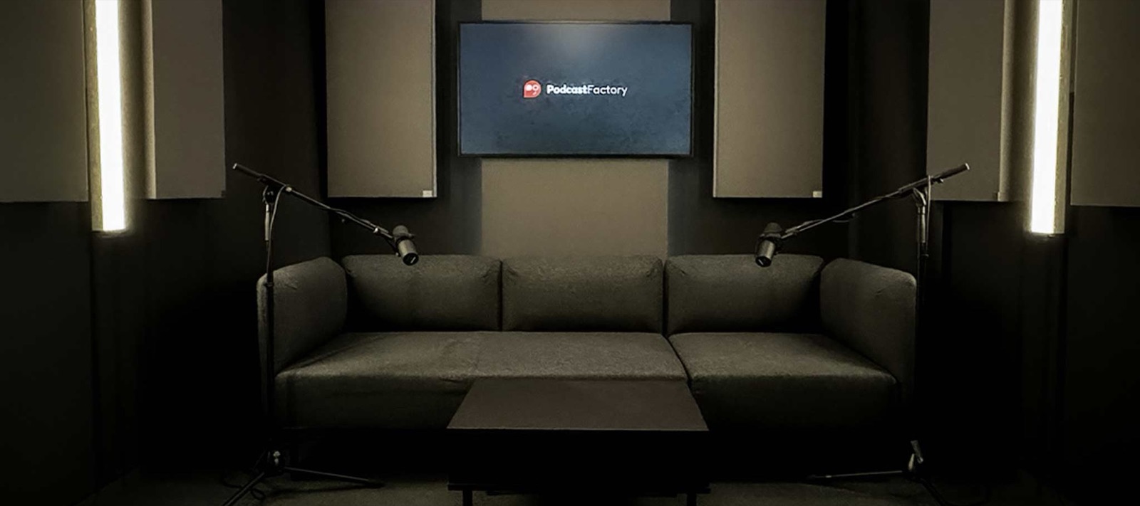 Totale des Podcast-Studios mit Akustikpaneelen und Lichtleisten