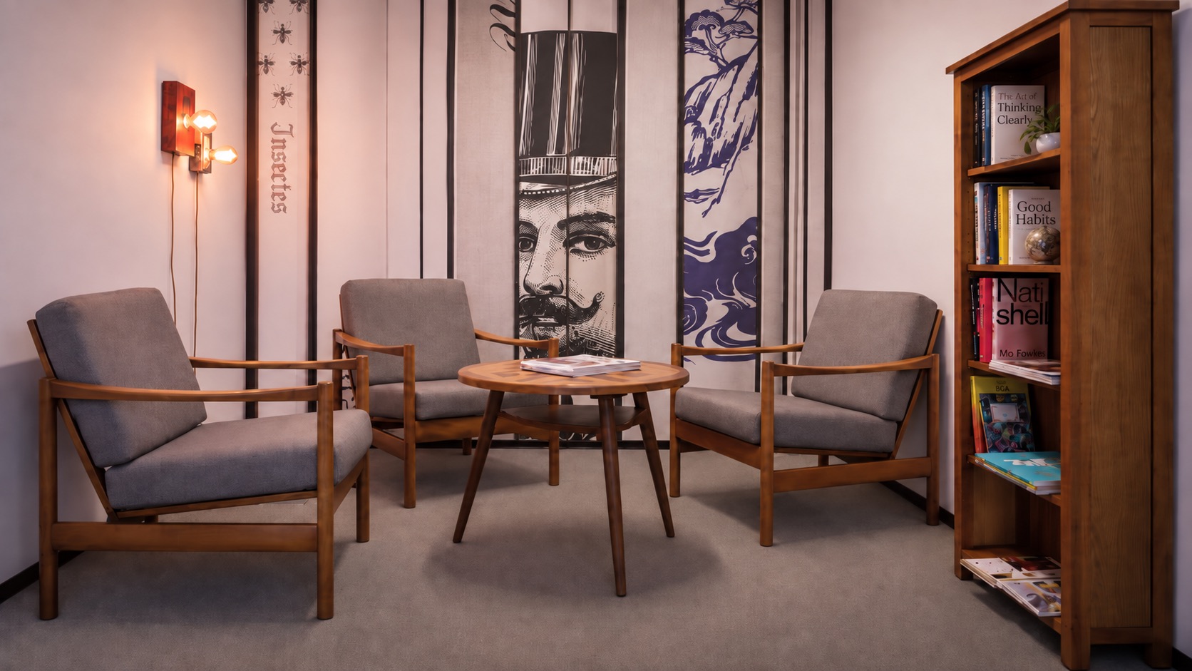 Die Bibliothek im Office Park 4: drei Sessel um einen runden Holztisch, Bücherregal und Wandbilder