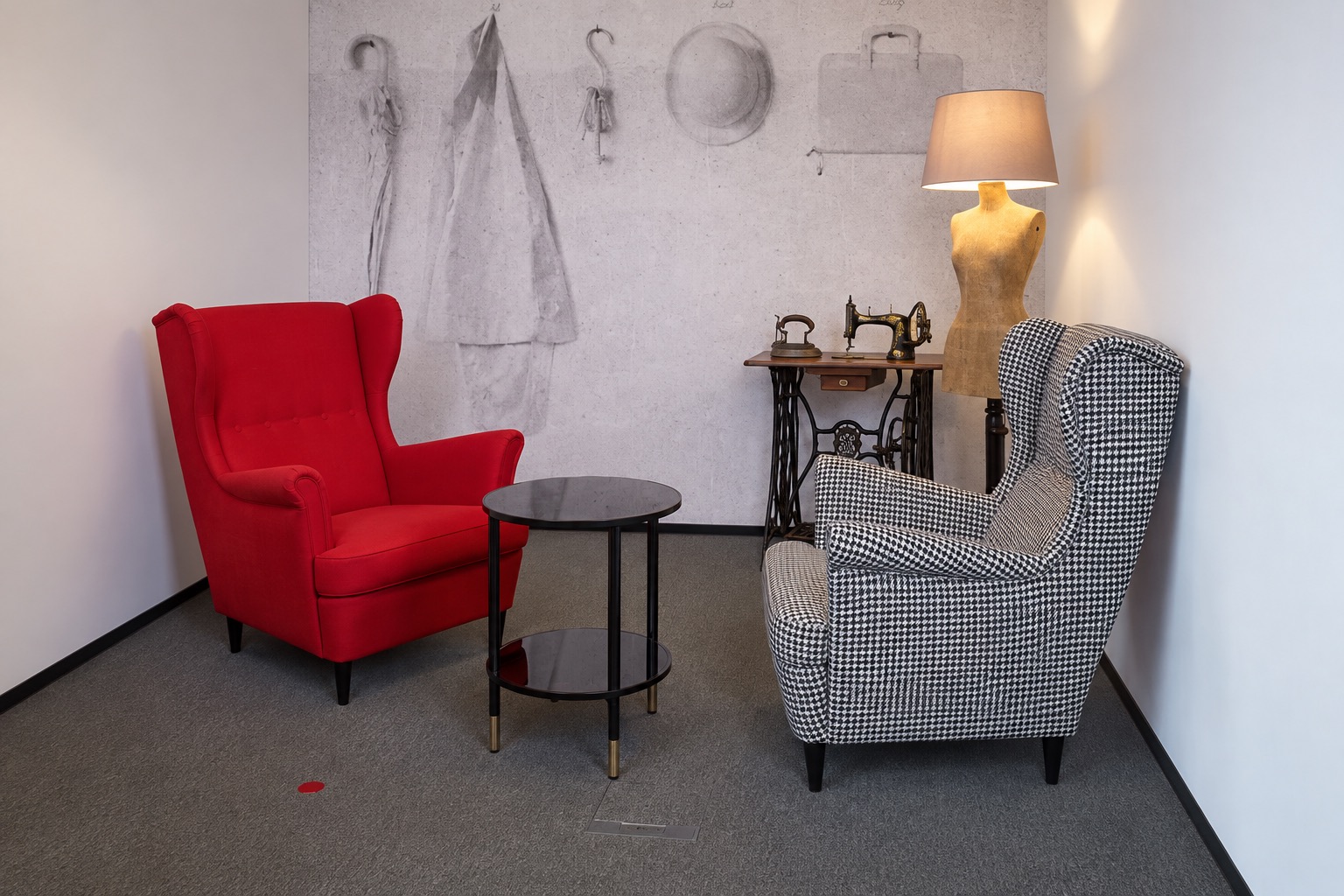 Die Schneiderei im Office Park 4: roter Ohrensessel und Ohrensessel im Hahnentrittmuster, dahinter Nähmaschine und Schneiderpuppe als Stehlampe