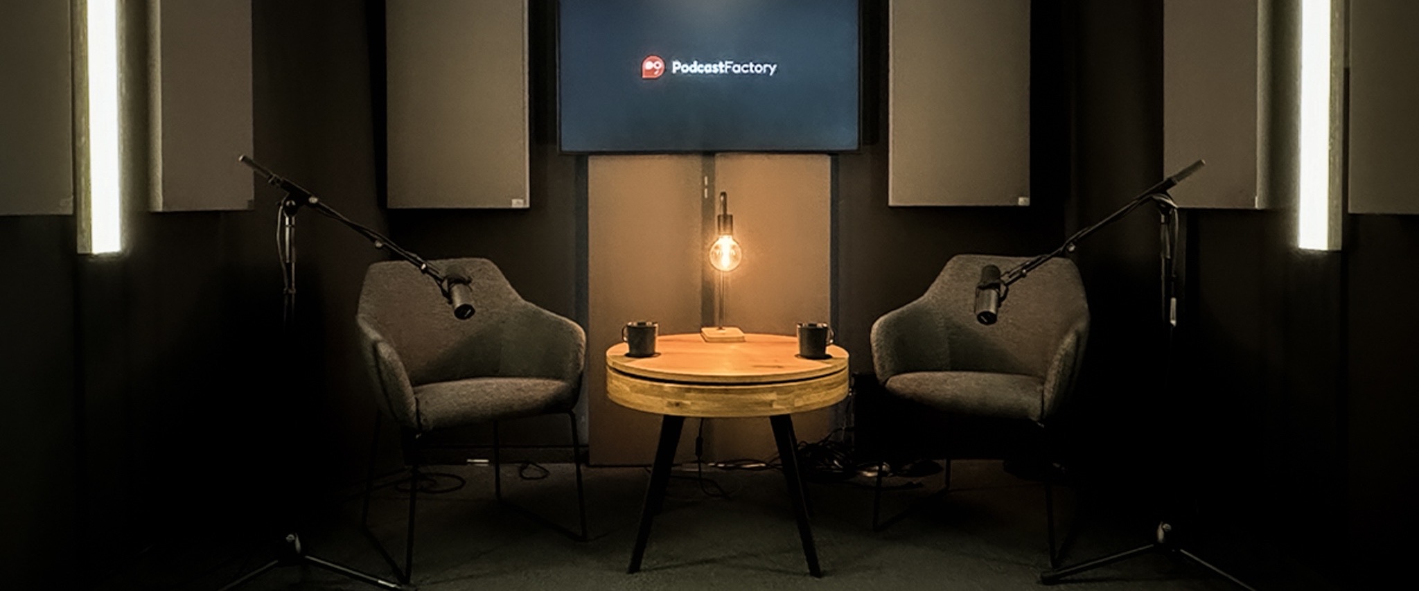 Lounge-Set im Podcast-Studio mit zwei Sesseln, Beistelltisch und Mikrofonständern
